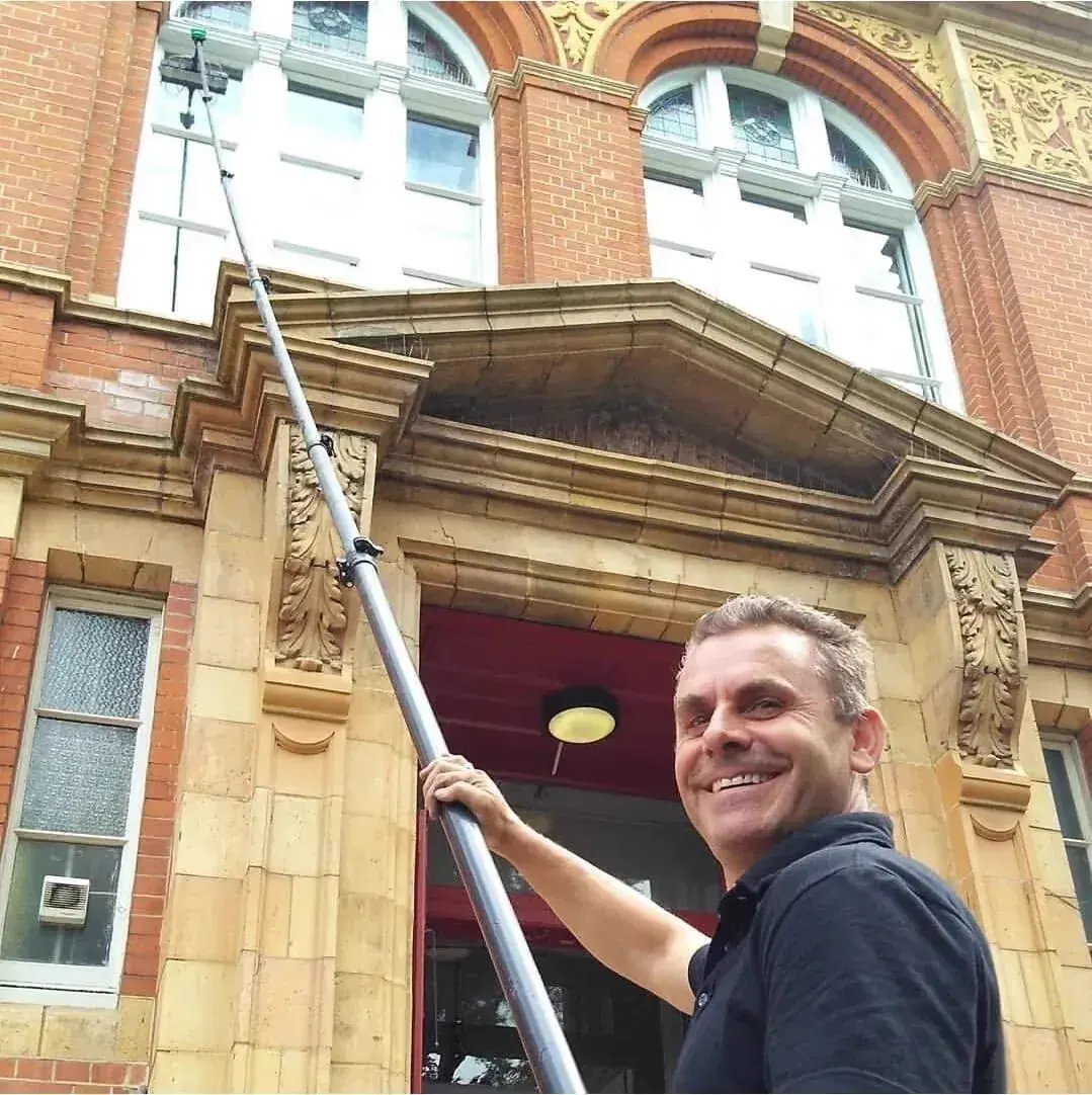 Jem Bici — Director, Chislehurst & Bickley Window Cleaners, using a water-fed pole on a historic building